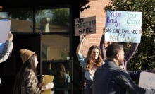 A group of protesters hold up signs outside an anti-abortion centers. One sign reads, "Your body, your choice. We can take you to a real clinic."