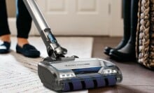 person vacuums the floor with Shark vacuum 