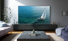 Samsung TV with ocean screensaver on TV stand in living room