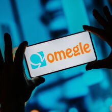 The Omegle logo is seen displayed on a smartphone screen