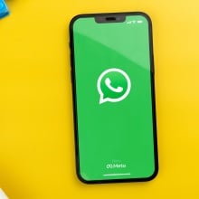 WhatsApp on a yellow desk with colorful accessories