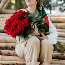 woman holding huge bouquet of roses