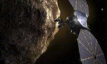An artist's conception of a spacecraft inspecting a Trojan asteroid.