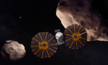 An artist's depiction of the Lucy spacecraft approaching Trojan asteroids.