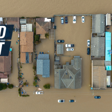 Bird's-eye view shot shows suburban houses submerged by floods. Caption reads "Flood alert."