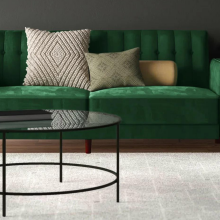Living room featuring green velvet sofa and round coffee table