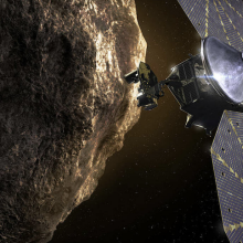 An artist's conception of a spacecraft inspecting a Trojan asteroid.