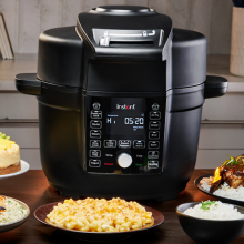 Instant Pot Duo Crisp Ultimate Lid on countertop with plates of food