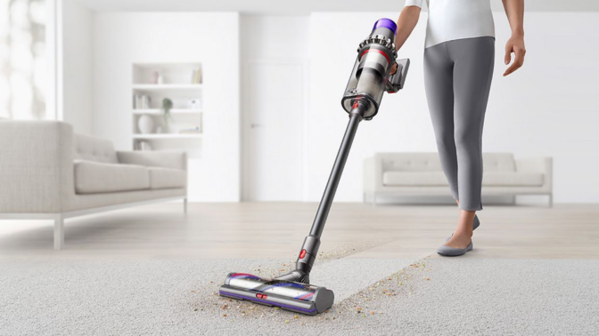 woman vacuuming rug with dyson outsize plus